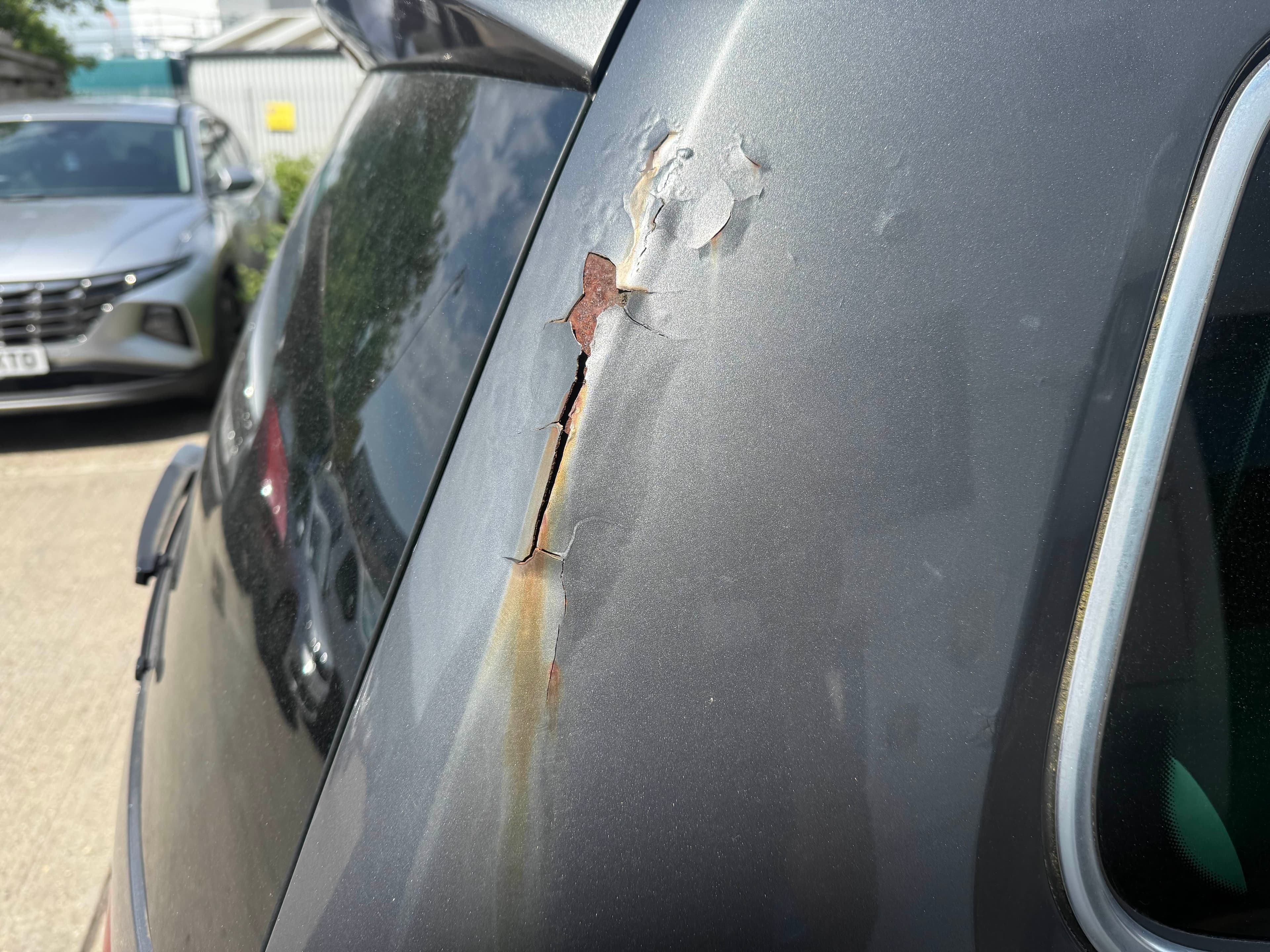 Corroded and damaged grey rear pillar before repair